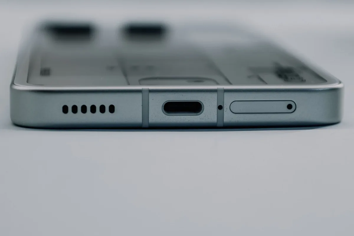 Teknisyen telefonun şarj soketini mikroskop altında temizleyip onarıyor